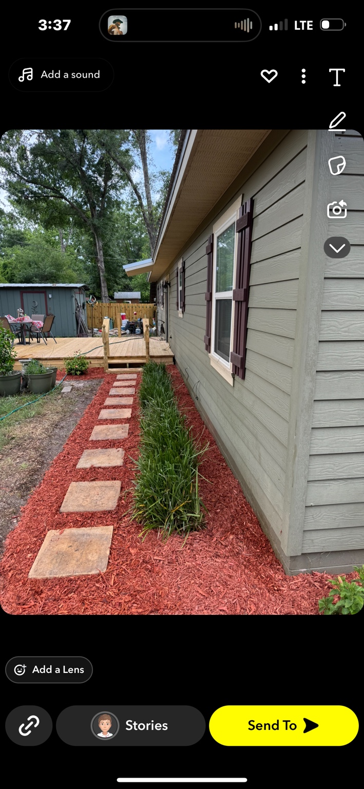 After: tidied planting bed with fresh red mulch and a defined stepping-stone path